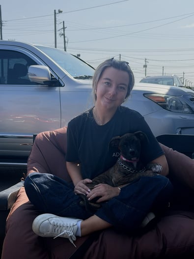 Adcom employee sitting with a dog